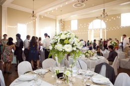 A tall centerpiece on a silver candlestick, at the Great Hall at Greenlake. Floressence. Alyssa Rose Photography.