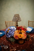 Floral centerpiece composed of three arrangements surrounding a table lamp, by Floressence.