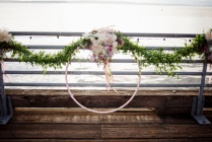 A hula hoop wrapped in vintage ribbon hangs from the railing at Ray's Boathouse, with floral designs by Floressence.