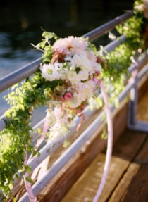 A hula hoop wrapped in vintage ribbon hangs from the railing at Ray's Boathouse, with floral designs by Floressence.