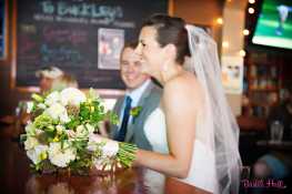 A bride and her bouquet, along with the groom, at a neighborhood bar. Floral design by Floressence.